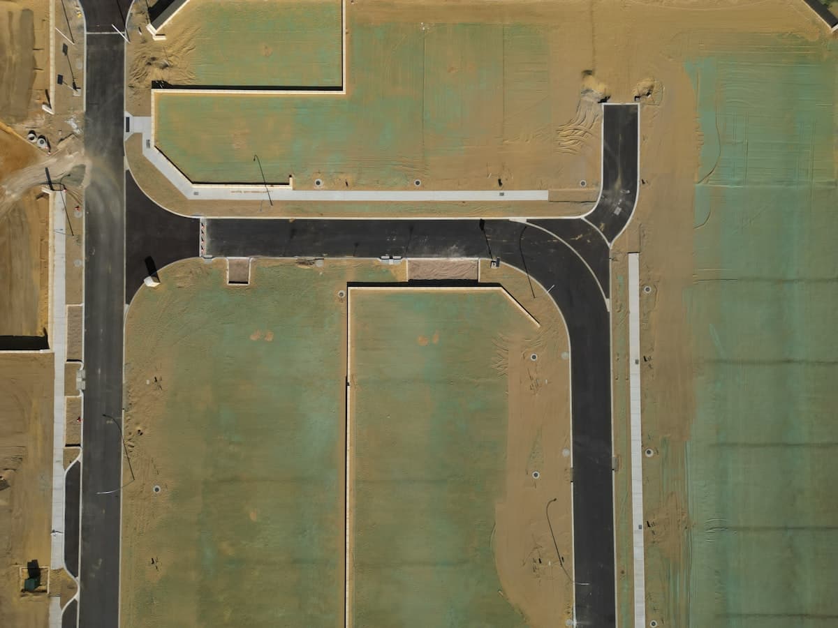 Aerial view of a new estate layout with graded roads and marked plots