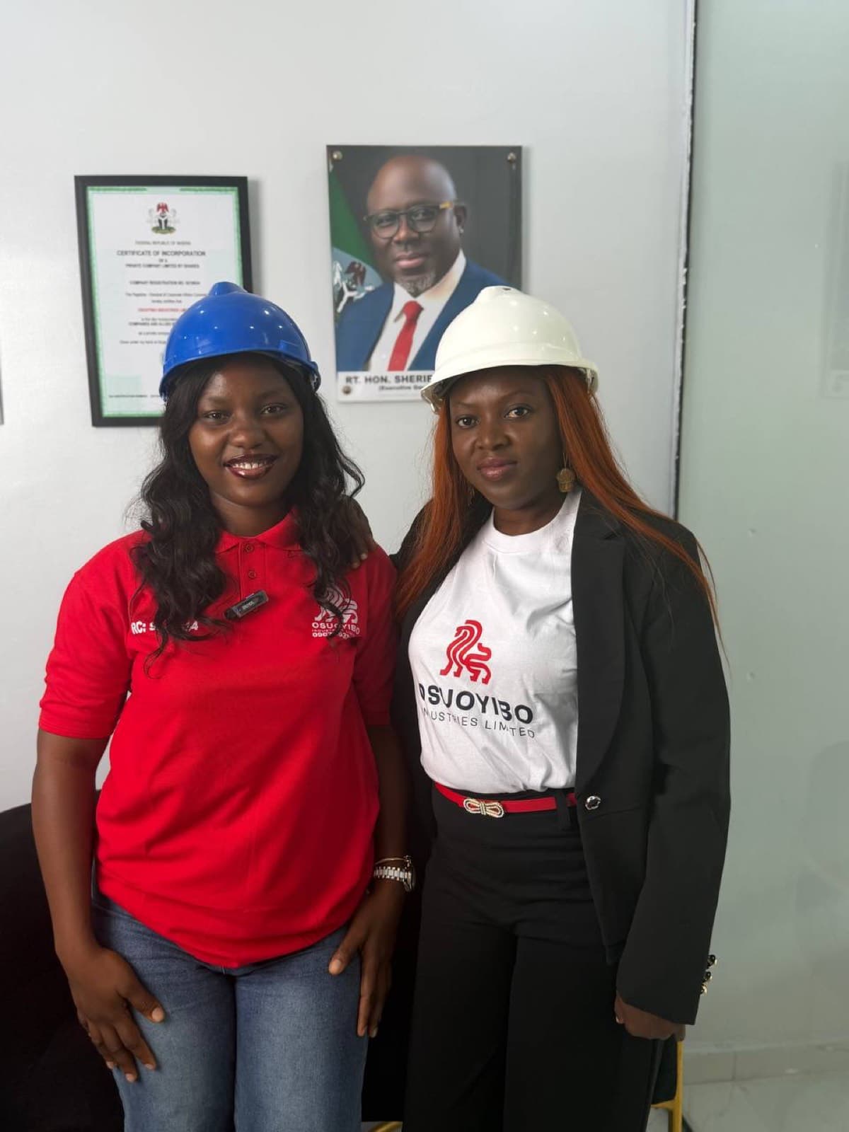 Osuoyibo staff in branded gear beside the company's Certificate of Incorporation